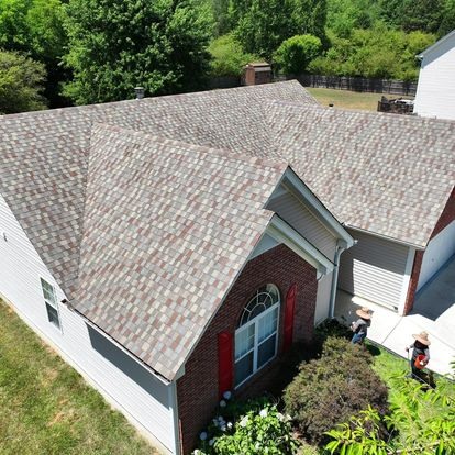 Aerial view of a finished gray architectural shingle roof on a brick home